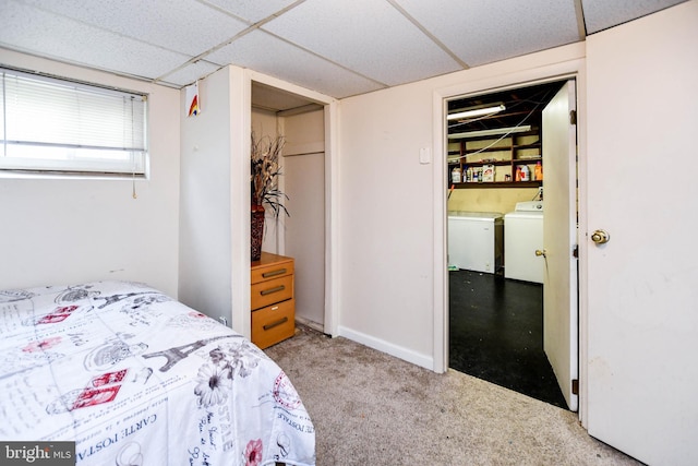 bedroom with washer and clothes dryer, a paneled ceiling, and light colored carpet
