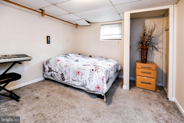 bedroom with a paneled ceiling, baseboards, and carpet