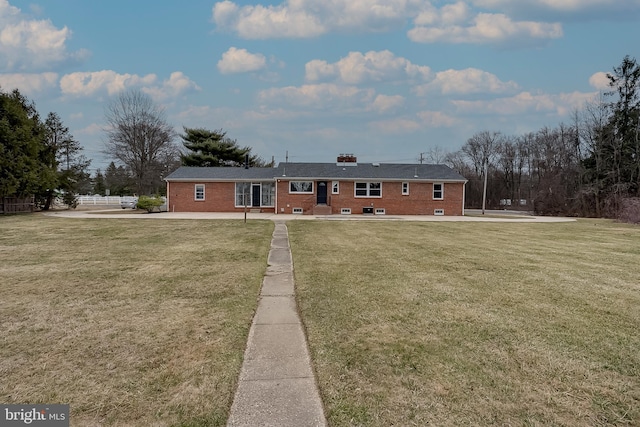 ranch-style house with a front yard and brick siding