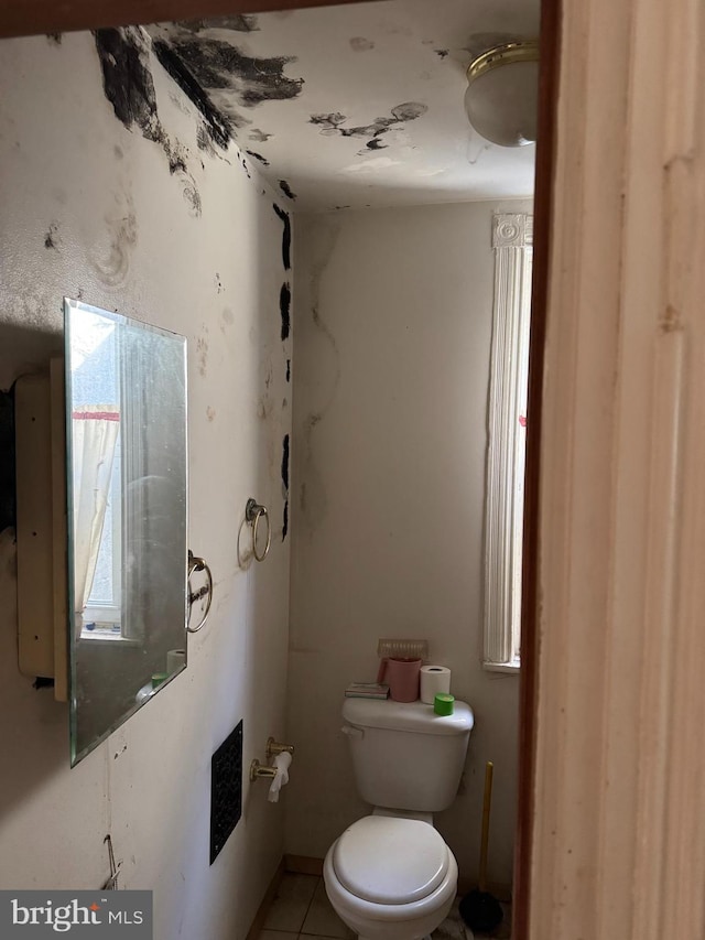 half bath with tile patterned floors and toilet