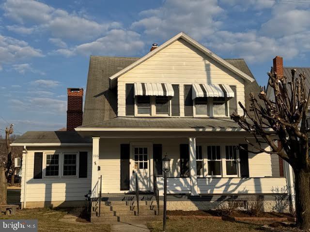 view of front of property with a porch and a chimney