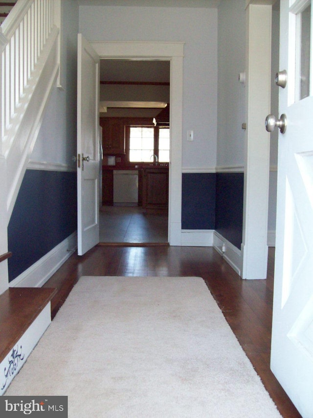 hallway with baseboards and wood finished floors