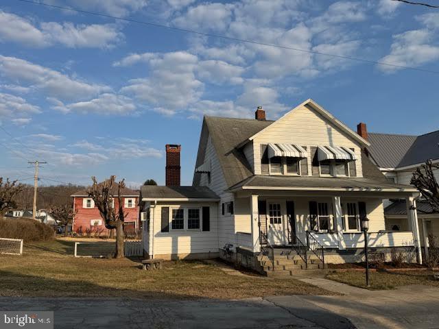 bungalow-style house with covered porch and a chimney