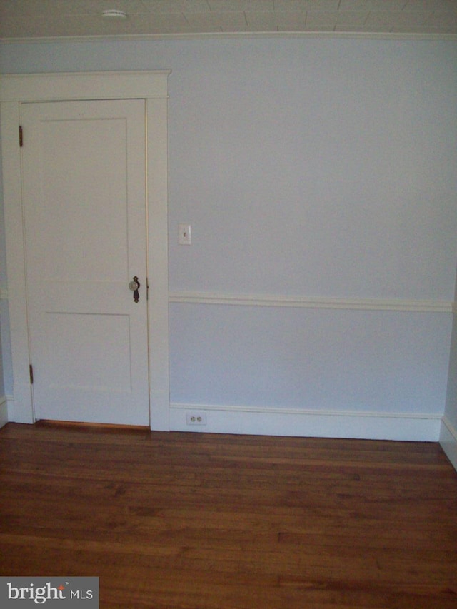 unfurnished room featuring baseboards and wood finished floors