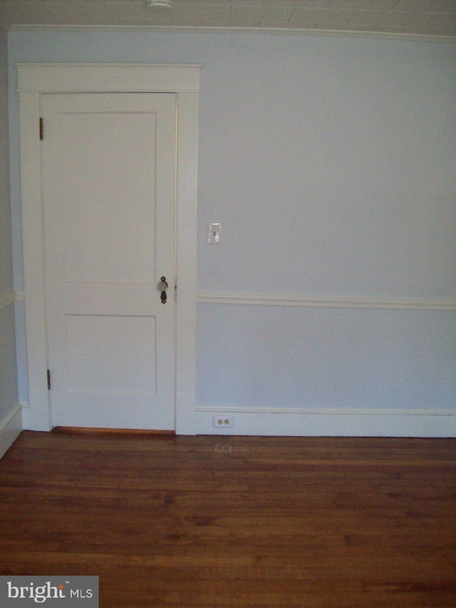 unfurnished room with baseboards and wood finished floors