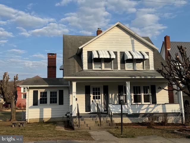 view of front facade featuring a porch and a chimney