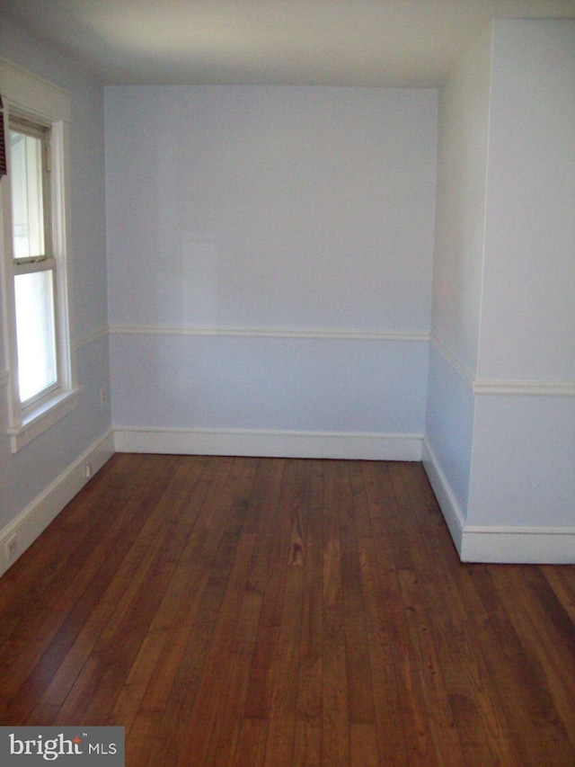 empty room with hardwood / wood-style floors and baseboards