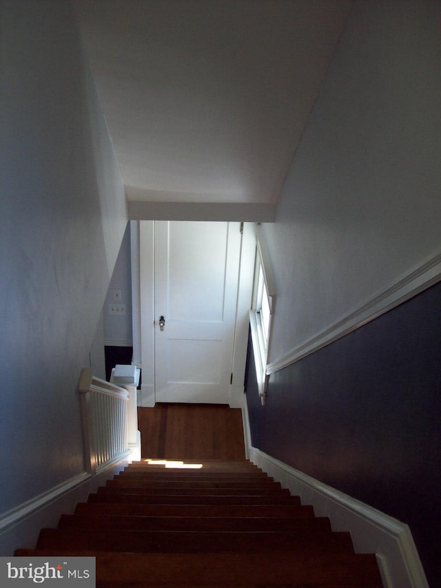 stairs featuring wood finished floors and baseboards