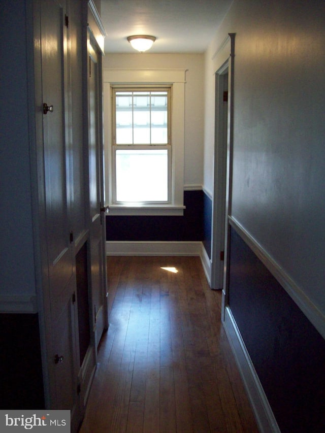 hall with baseboards and dark wood finished floors