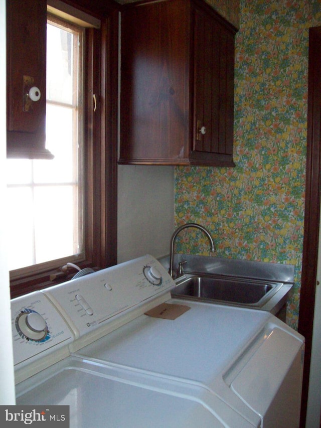 laundry area with washer and clothes dryer, cabinet space, a wealth of natural light, and a sink