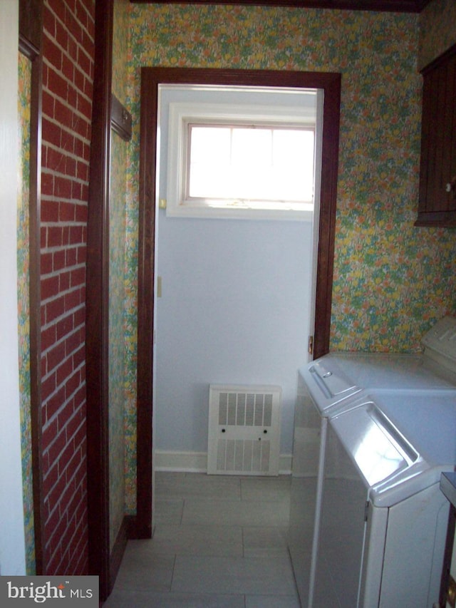 washroom with visible vents, wallpapered walls, baseboards, washer and clothes dryer, and laundry area