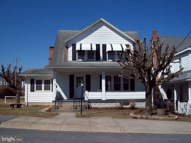 view of front of home featuring covered porch and a chimney