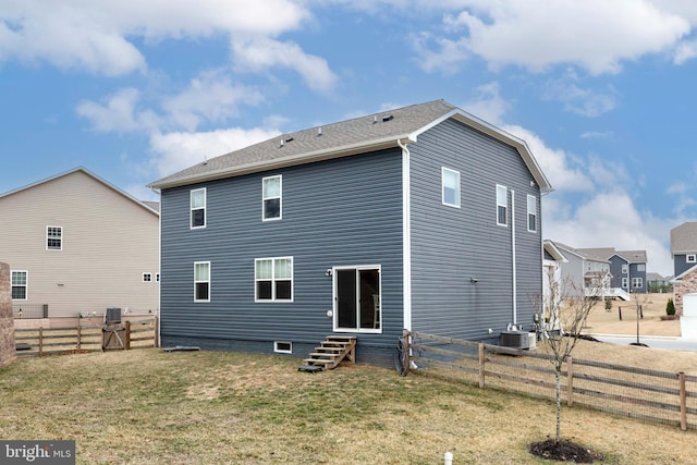 rear view of house with a yard, cooling unit, a fenced backyard, and entry steps