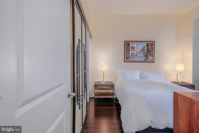 bedroom with dark wood-style flooring