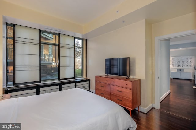 bedroom featuring wood finished floors and baseboards