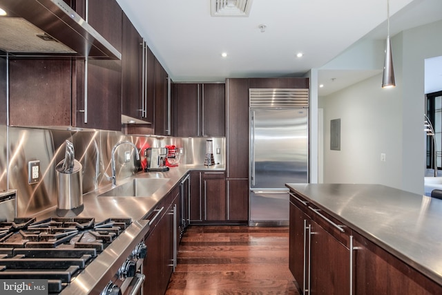 kitchen featuring dark wood-style floors, a sink, stainless steel countertops, gas range oven, and stainless steel built in refrigerator
