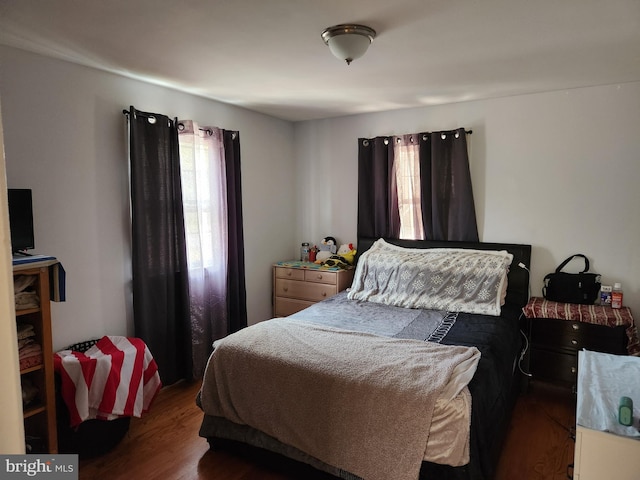 bedroom with multiple windows and wood finished floors