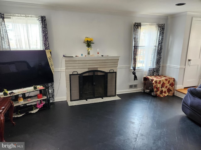 living room with crown molding, plenty of natural light, and visible vents