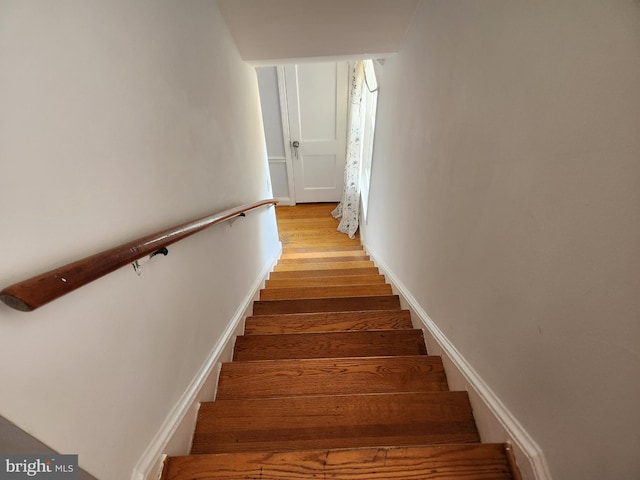 stairs featuring wood finished floors