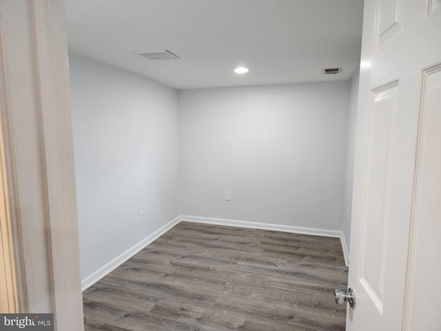 spare room with visible vents, baseboards, and wood finished floors