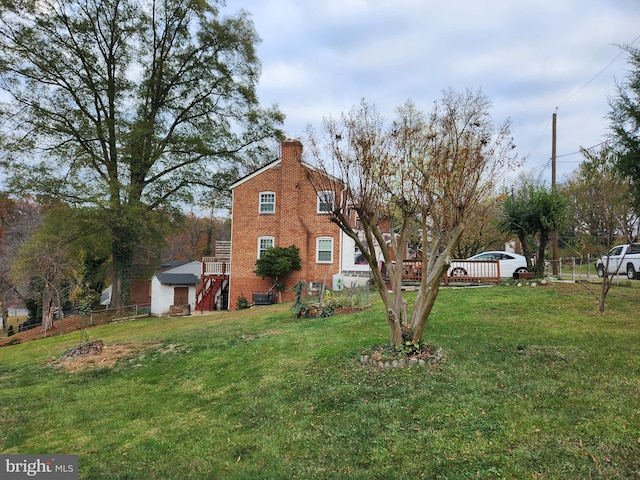 view of property exterior with brick siding, a lawn, fence, and a chimney