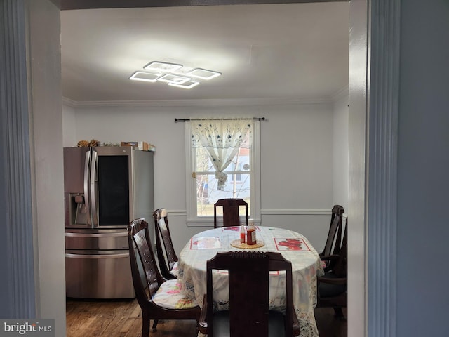 dining room with wood finished floors and ornamental molding