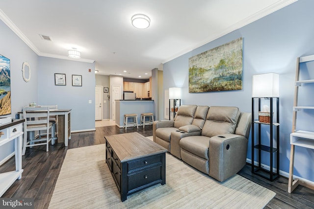 living room with visible vents, wood finished floors, baseboards, and ornamental molding