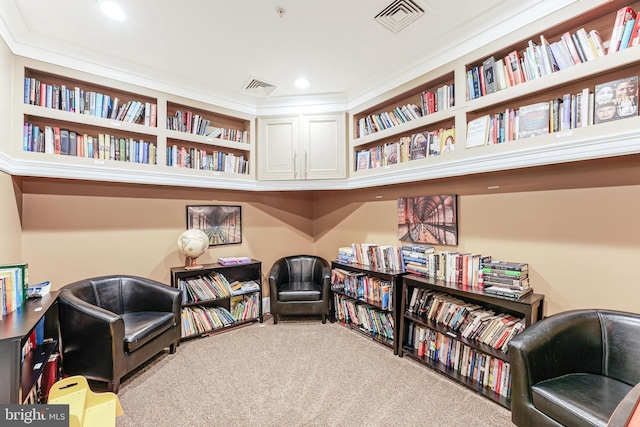 sitting room featuring wall of books, visible vents, recessed lighting, and carpet floors