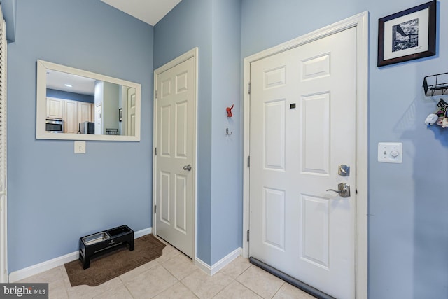 entryway with light tile patterned floors and baseboards