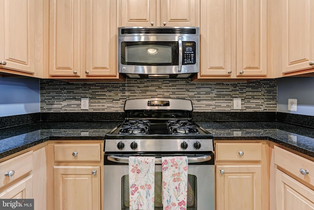 kitchen with dark countertops, light brown cabinets, backsplash, and appliances with stainless steel finishes