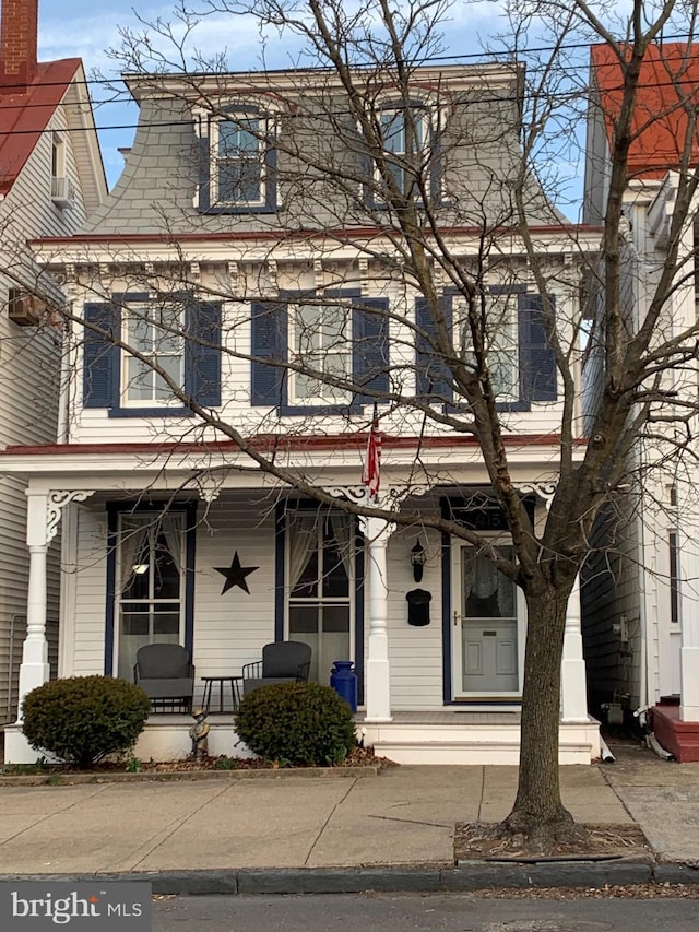 victorian home featuring mansard roof and covered porch