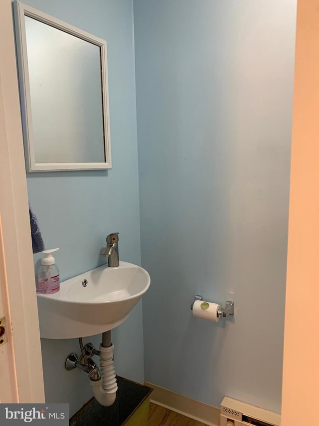 bathroom with a sink and a baseboard radiator