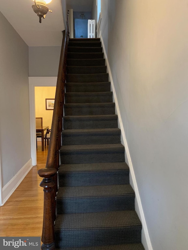 stairway featuring baseboards and wood finished floors