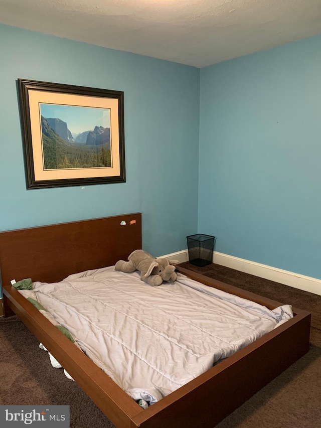 bedroom featuring baseboards and carpet