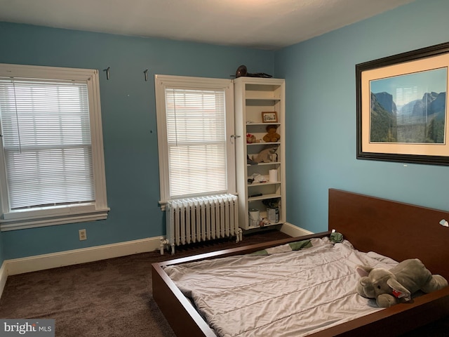 carpeted bedroom featuring baseboards, multiple windows, and radiator