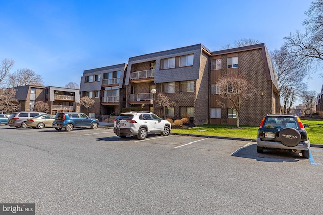 view of building exterior featuring a residential view and uncovered parking