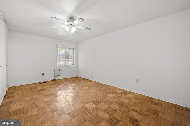 spare room featuring baseboards and a ceiling fan