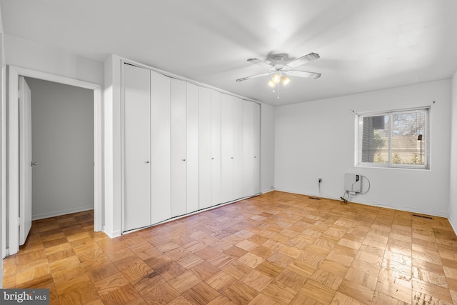 unfurnished bedroom with a closet and a ceiling fan