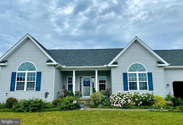 ranch-style home with a front yard and roof with shingles