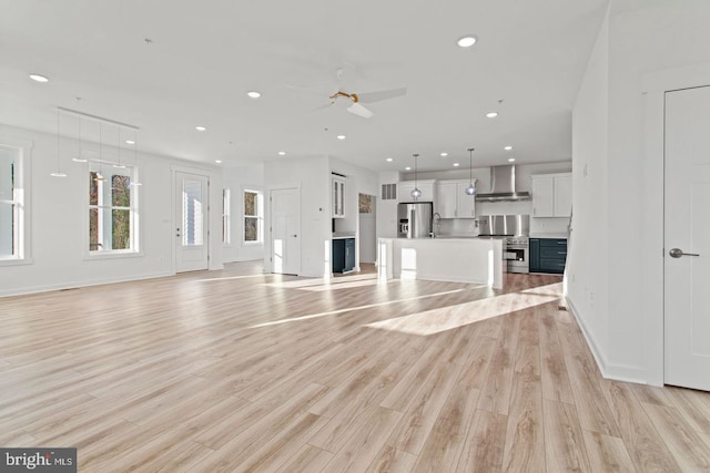 unfurnished living room featuring recessed lighting, baseboards, light wood-style floors, and ceiling fan