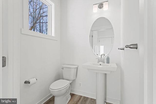 bathroom featuring baseboards, toilet, and wood finished floors