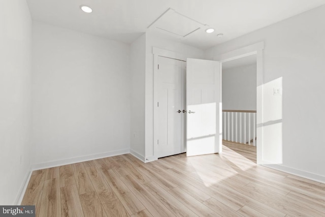 spare room featuring recessed lighting, baseboards, and light wood-style floors