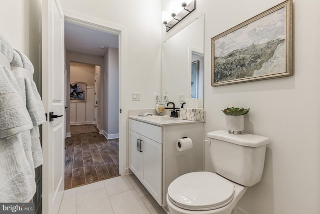 bathroom with tile patterned floors, baseboards, toilet, and vanity