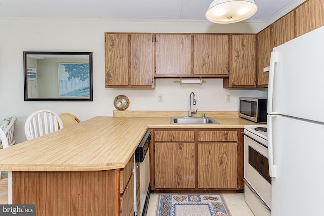 kitchen with white appliances, a peninsula, a sink, light countertops, and brown cabinets