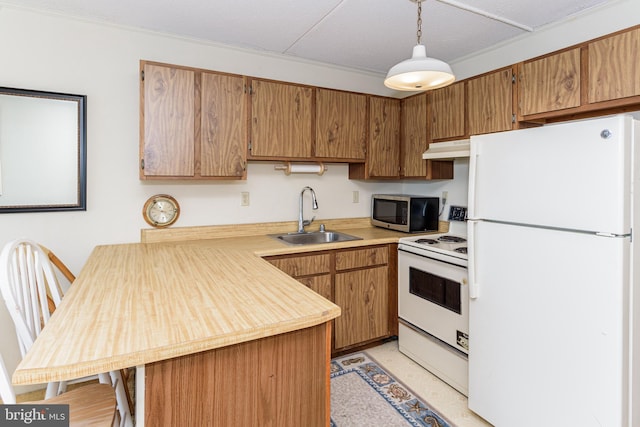 kitchen with under cabinet range hood, light countertops, brown cabinets, white appliances, and a sink