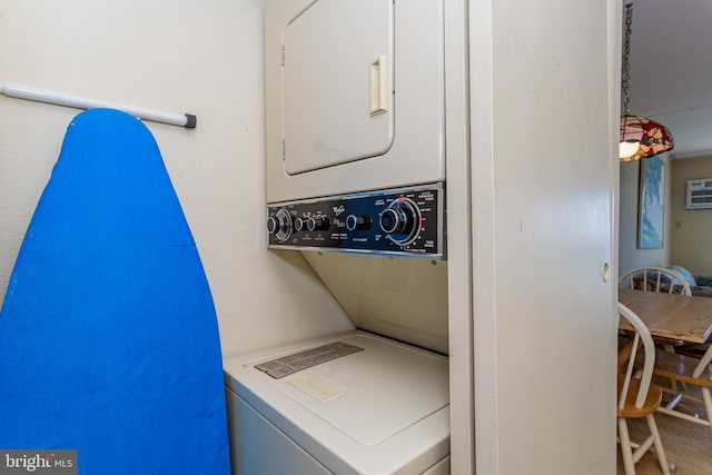 washroom featuring stacked washer and clothes dryer and laundry area