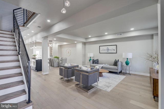 living area featuring stairs, recessed lighting, visible vents, and light wood finished floors