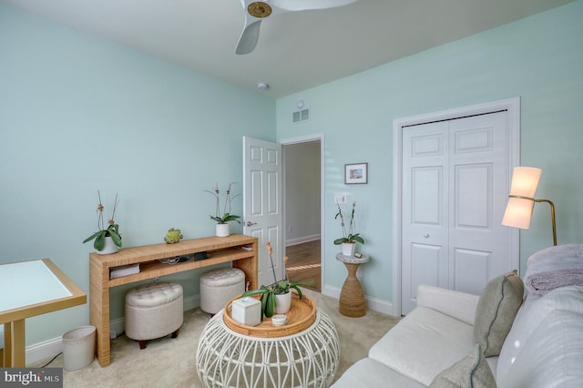 sitting room with visible vents, baseboards, carpet floors, and ceiling fan