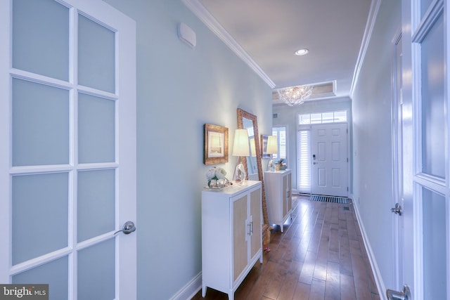 interior space featuring dark wood finished floors, a notable chandelier, baseboards, and ornamental molding