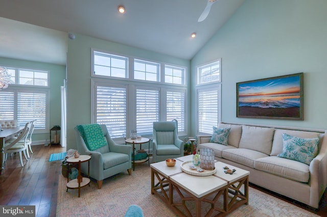 living area with a ceiling fan, a healthy amount of sunlight, wood finished floors, and high vaulted ceiling